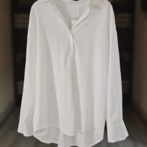 A timeless white button-down shirt made from lightweight fabric with a relaxed fit and a flattering high-low hem. Perfect for work, casual days, or layering.